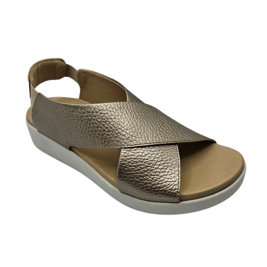 45 degree angled view of metallic gold leather sandal with crossed straps, white rubber outsole and elasticated back strap