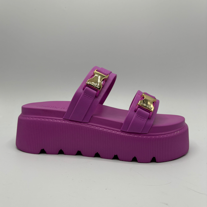 Purple sandal with gold buckles on a gray background