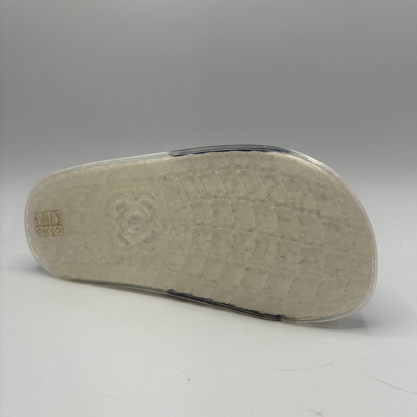 Close-up of a shoe sole with a brand logo on a gray background