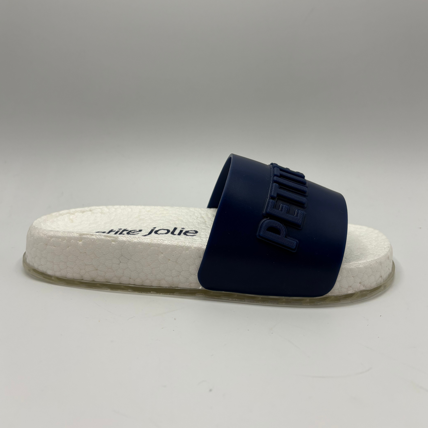 Navy slide sandal with white sole on a gray background