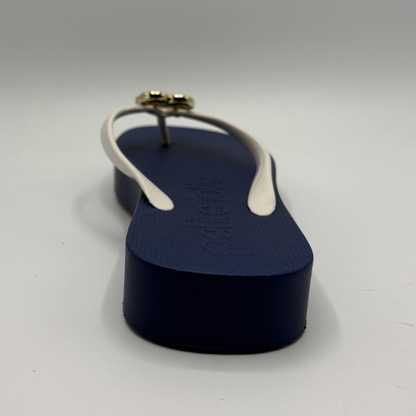 Navy blue sandal with white strap on a light gray background