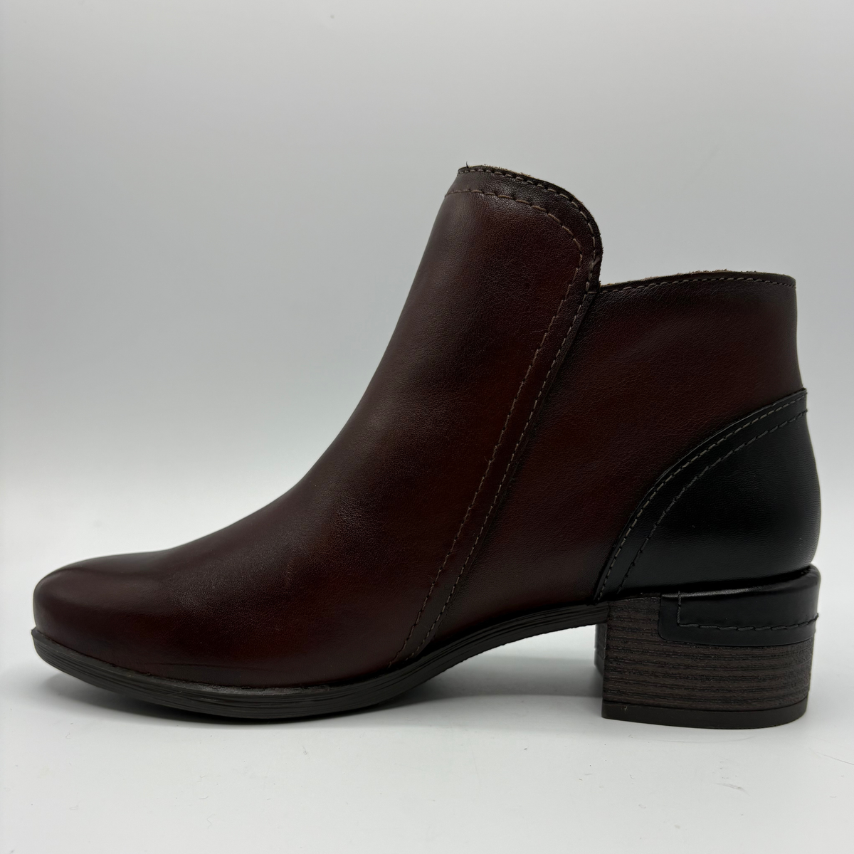 Left view of a brown leather ankle boot with a stacked heel and side zipper closure