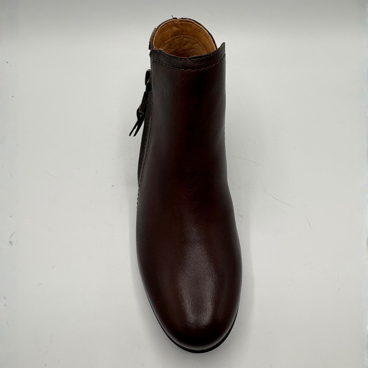 Top view of a brown leather ankle boot with a stacked heel and side zipper closure