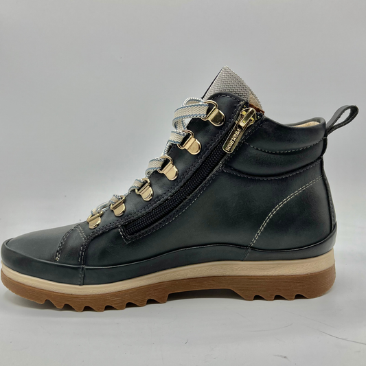 Black leather boot with brown sole on a gray background