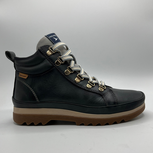 Black hiking boot with brown sole on a gray background