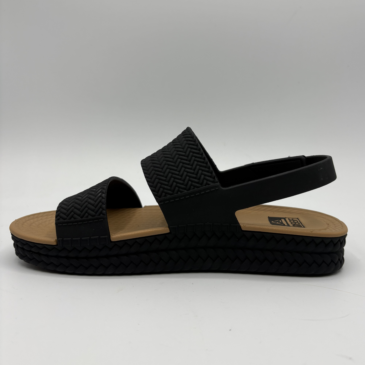 Left facing view of a black and tan braided strap sandals