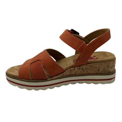 Left facing view of vegan wedge sandal with rusty orange straps on upper and buckle ankle strap