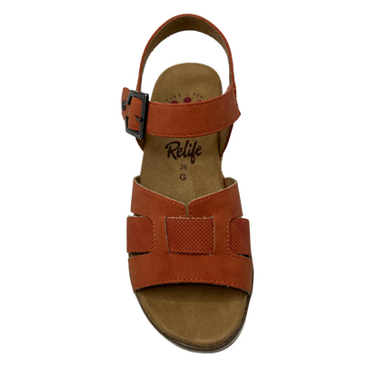 Top view of vegan wedge sandal with rusty orange upper and metal buckle on ankle strap
