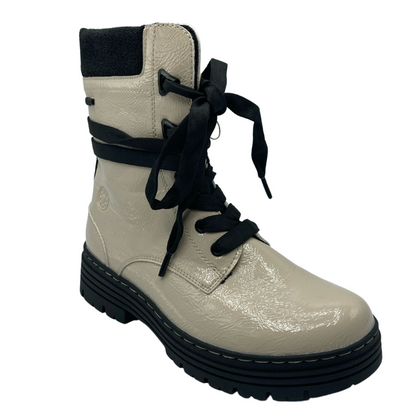 45 degree angled view of beige patent textile upper with black rubber sole and black laces