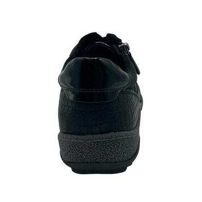 Heel view of back of a black vegan leather sneaker with grey rubber outsole
