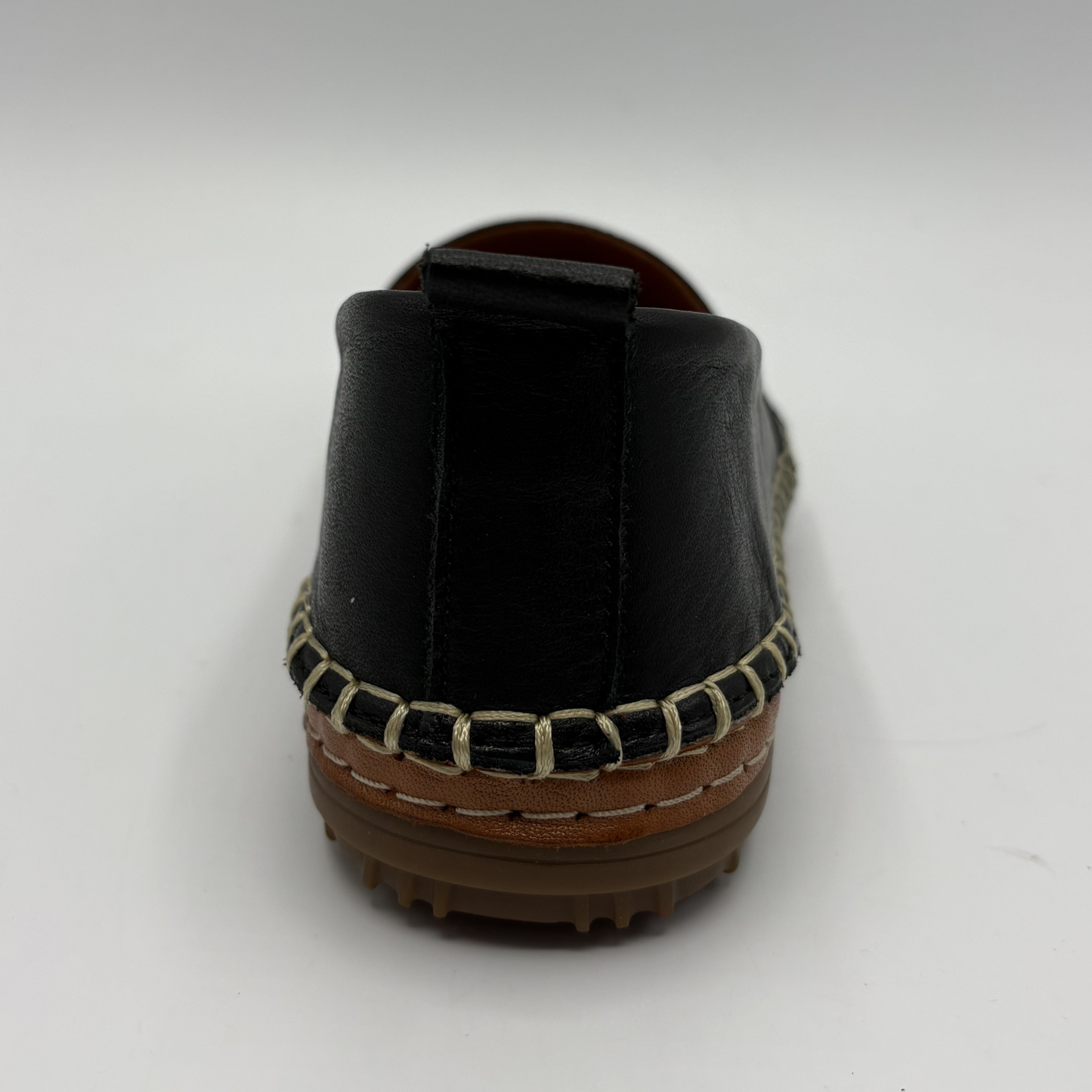 Black loafer with brown sole on a white background