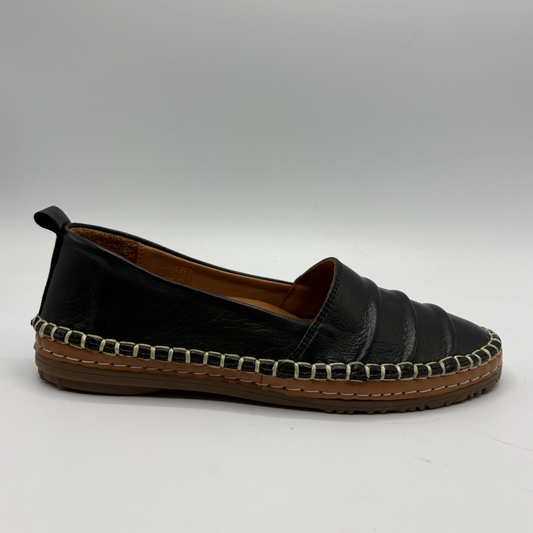 Black slip-on shoe with woven trim on a white background