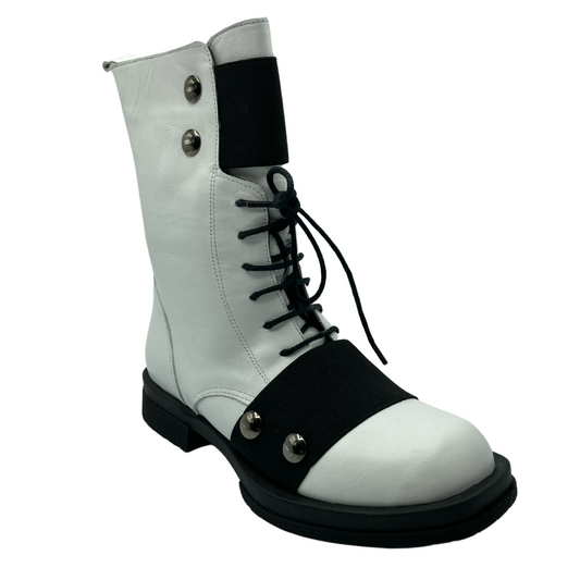 45 degree angled view of white leather short boot with black elastic detail and short block heel