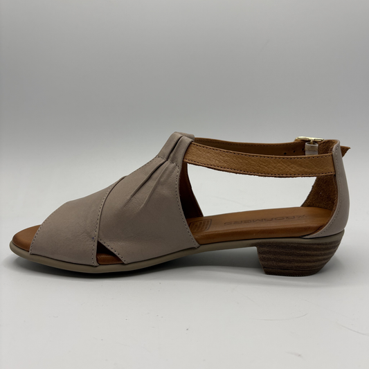 Brown sandal with criss-cross design on a gray background