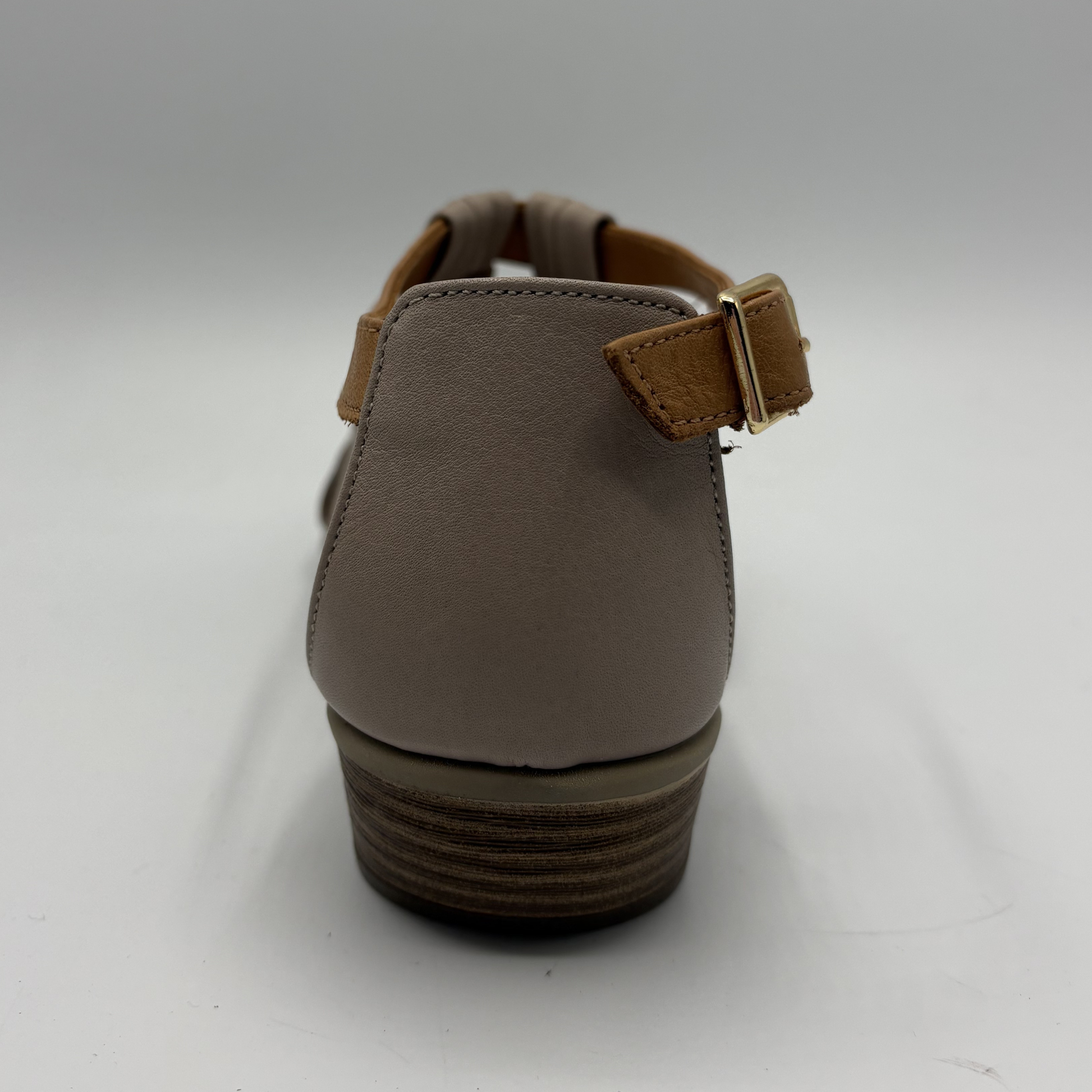 Brown sandal with a strap and buckle on a white background