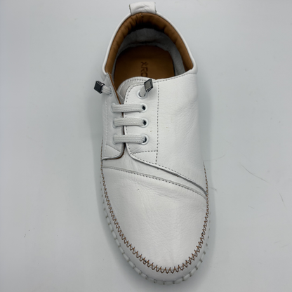 Top view of a white leather shoe with off center laces