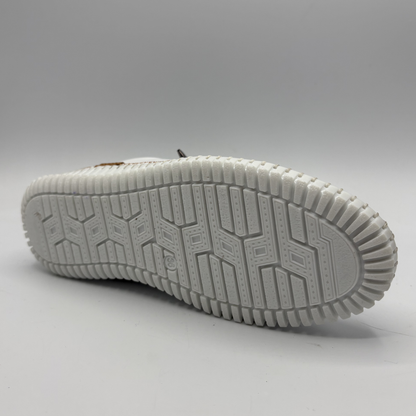Bottom view of a white leather shoe with off center laces