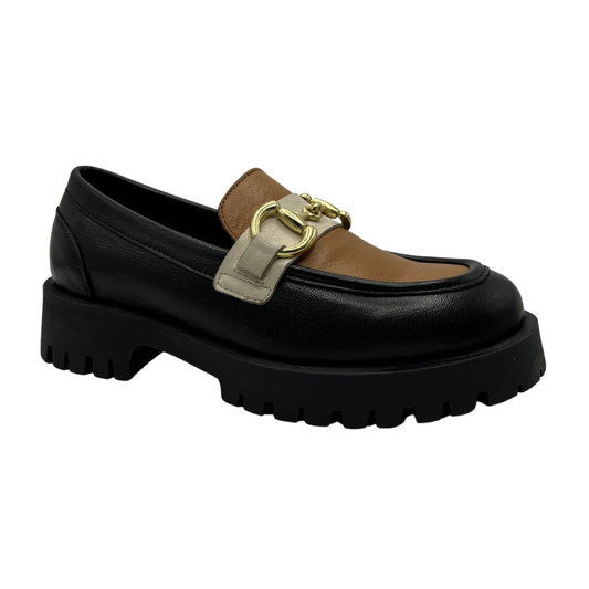 45 degree angled view of a black loafer with a brown tongue and eggnog coloured strap. Gold bit detail and black lug sole.