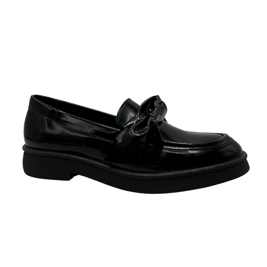 45 degree angled view of black patent leather loafer with knotted strap detail and black rubber outsole