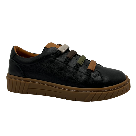 Angled view of a black leather sneaker with tan rubber outsole, elastic straps and padded collar
