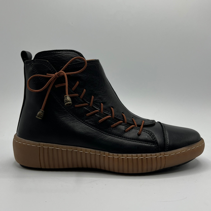 Black ankle boot with brown sole on a gray background