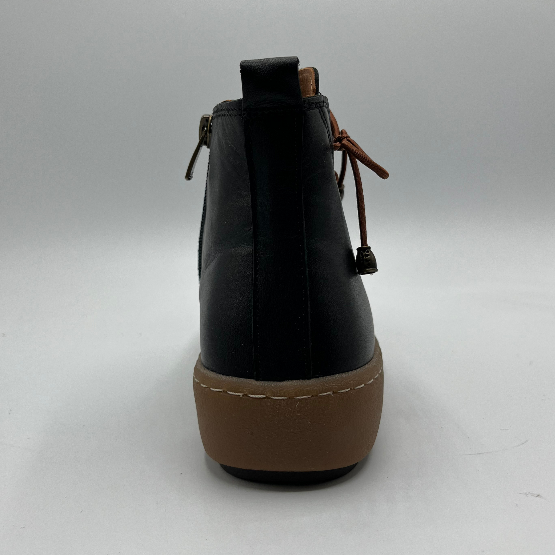 Black ankle boot with brown sole on a white background