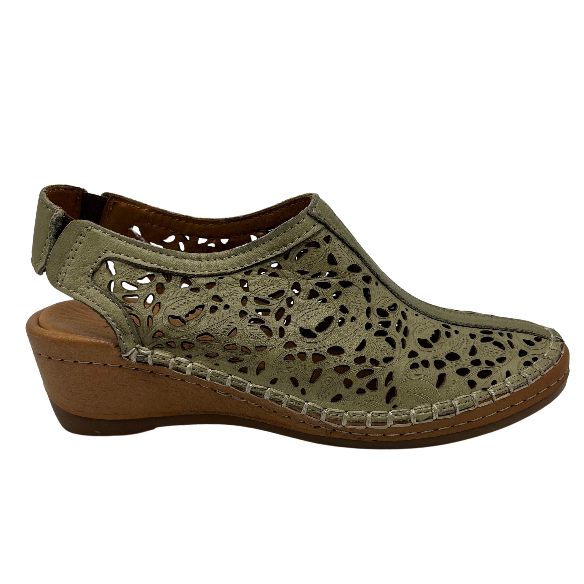 Right facing view of light green leather shoe with cut out design with low wedge heel