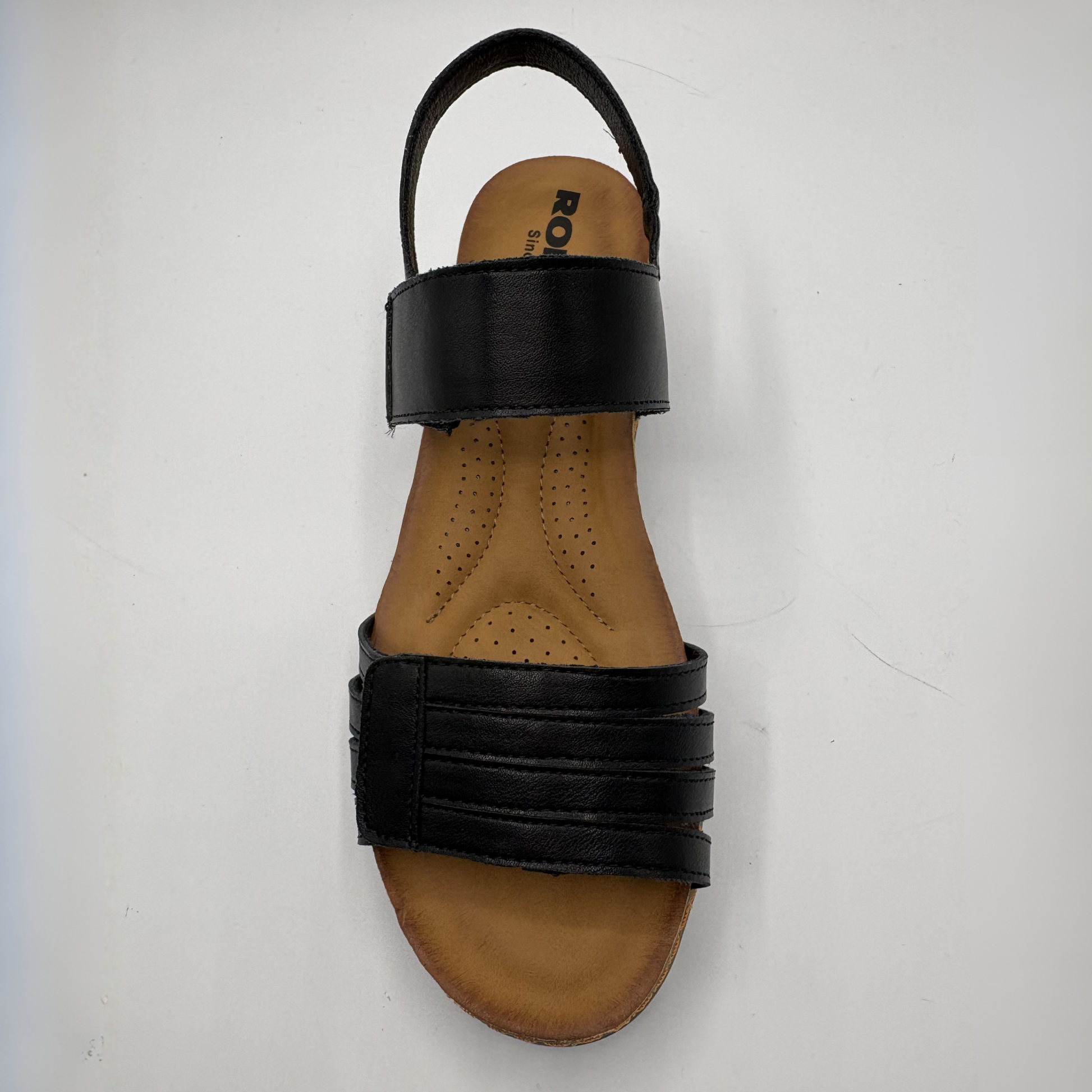 Black sandal with a tan insole on a white background