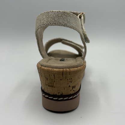 Beige sandal with cork wedge sole on a gray background