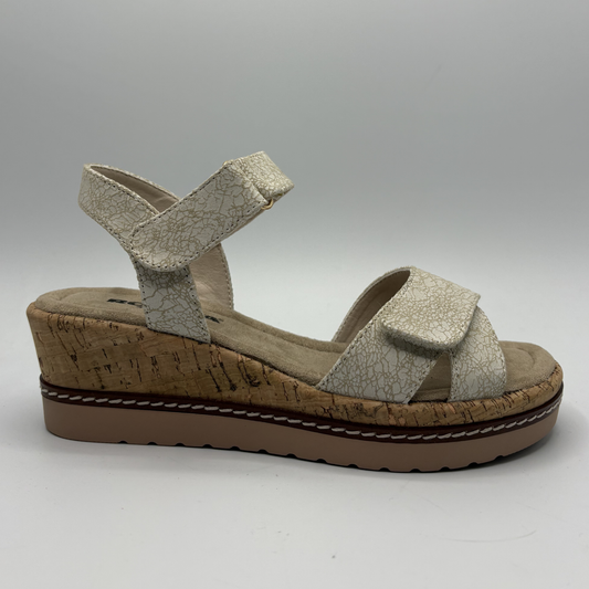 Beige sandal with cork wedge sole on a light gray background