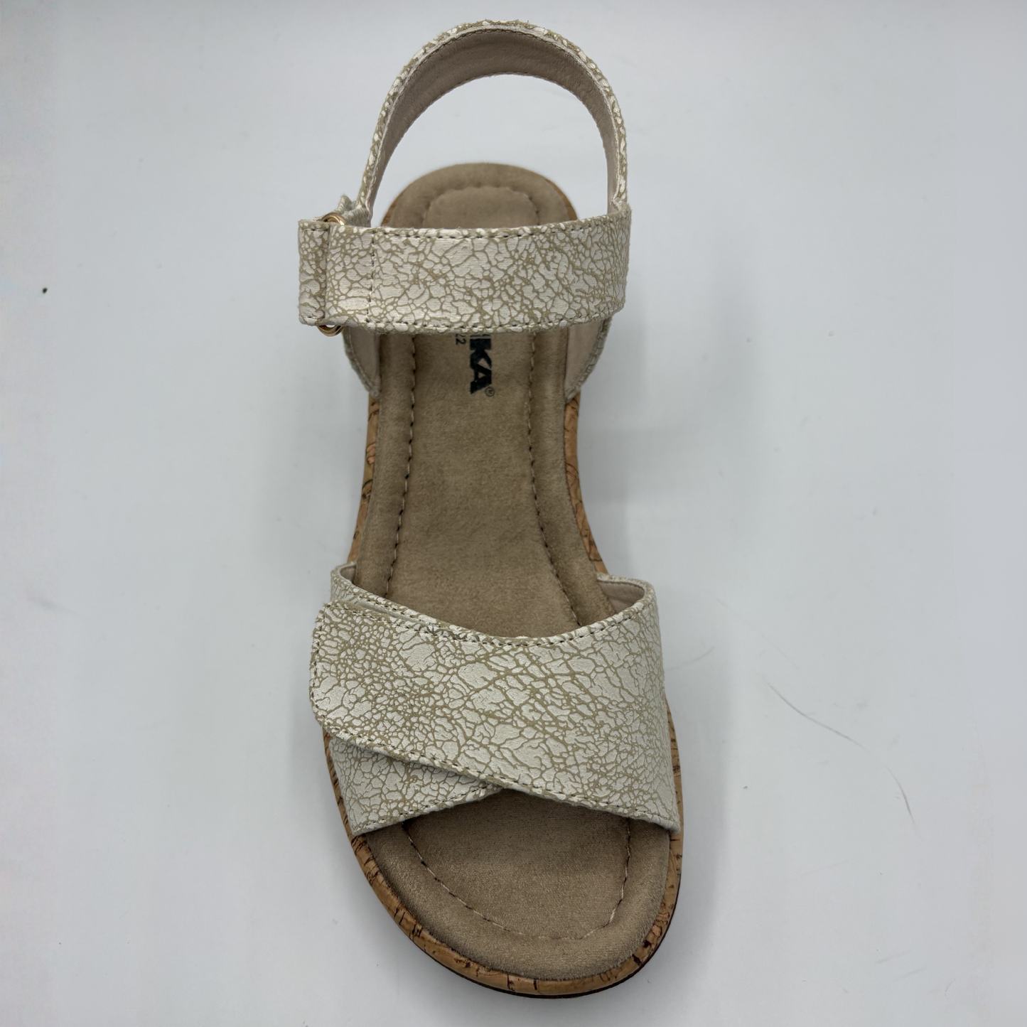 Beige sandal with criss-cross strap design on a white background