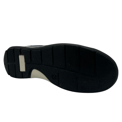 Bottom view of navy flat with black and white rubber outsole