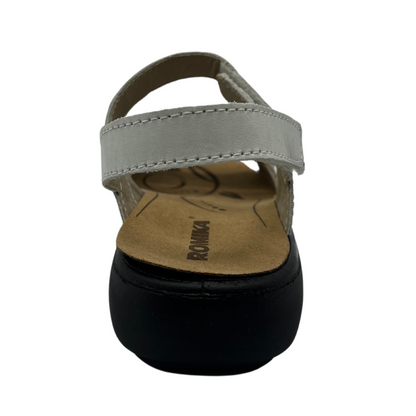 Back view of white leather sandal with velcro straps and black rubber outsole