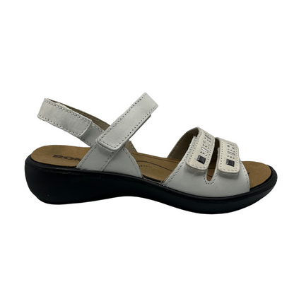 Right facing view of white leather sandal with black rubber outsole