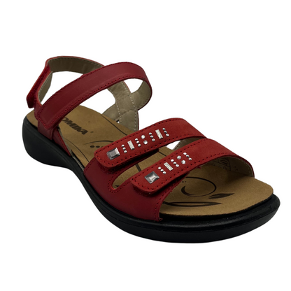 45 degree angled view of red leather sandal with black rubber outsole