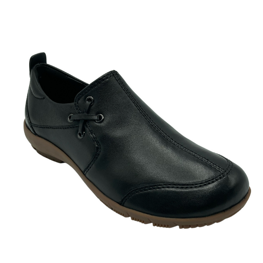 45 degree angled view of black leather shoe with x cross lace detail and brown rubber outsole
