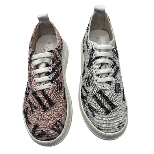 Top view of two mesh platform sneakers side by side. One is pink with black and the other one is white with black. Both have white laces and a white platform sole