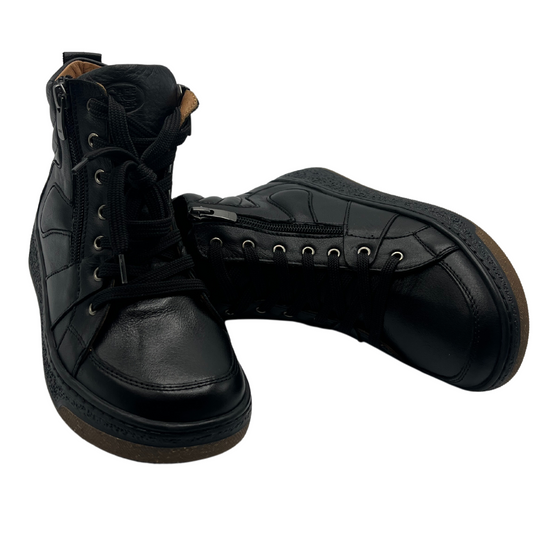 View of a pair of black leather boots with side zipper closures and black laces