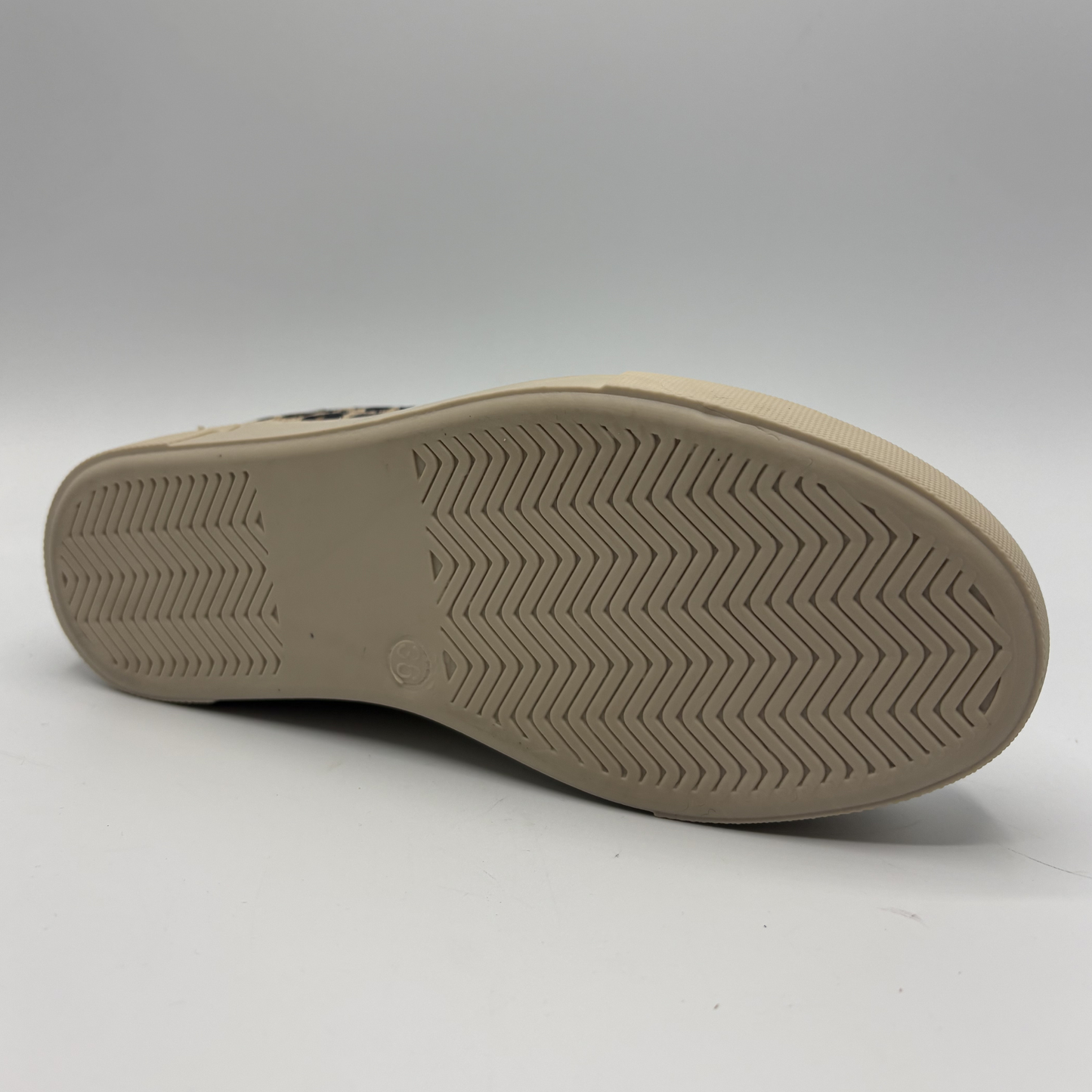 Bottom view of a leopard print sneaker with a beige rubber outsole