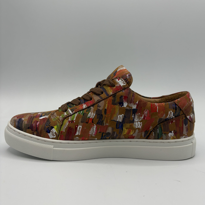 Left facing view of a leather sneaker with a side zip closure and white rubber outsole