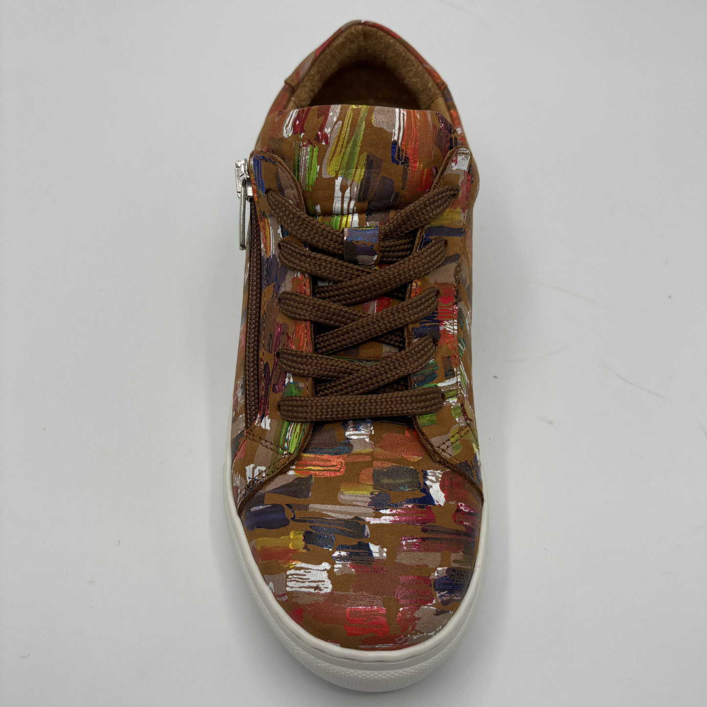 Top view of a leather sneaker with a side zip closure and white rubber outsole