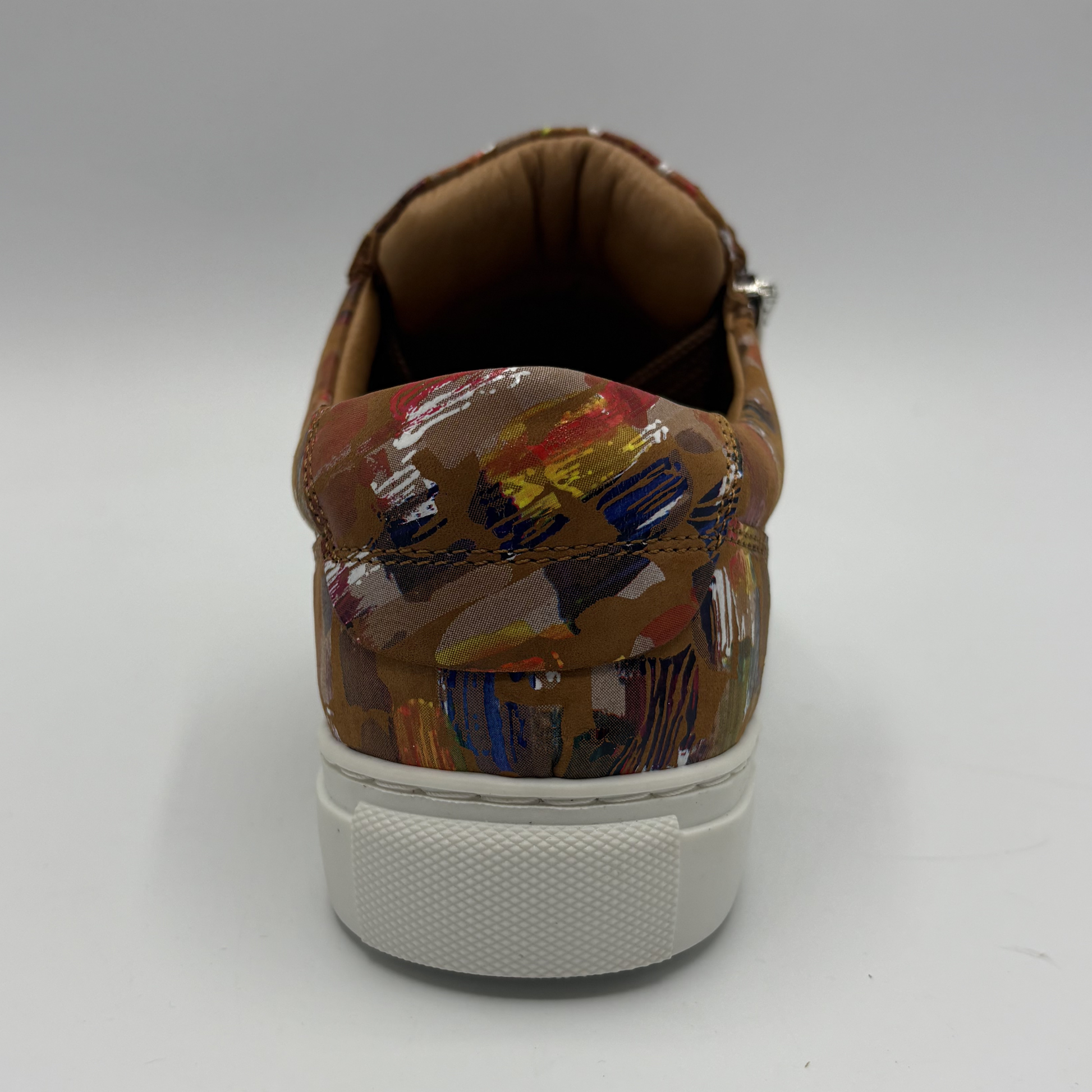 Back view of a leather sneaker with a side zip closure and white rubber outsole