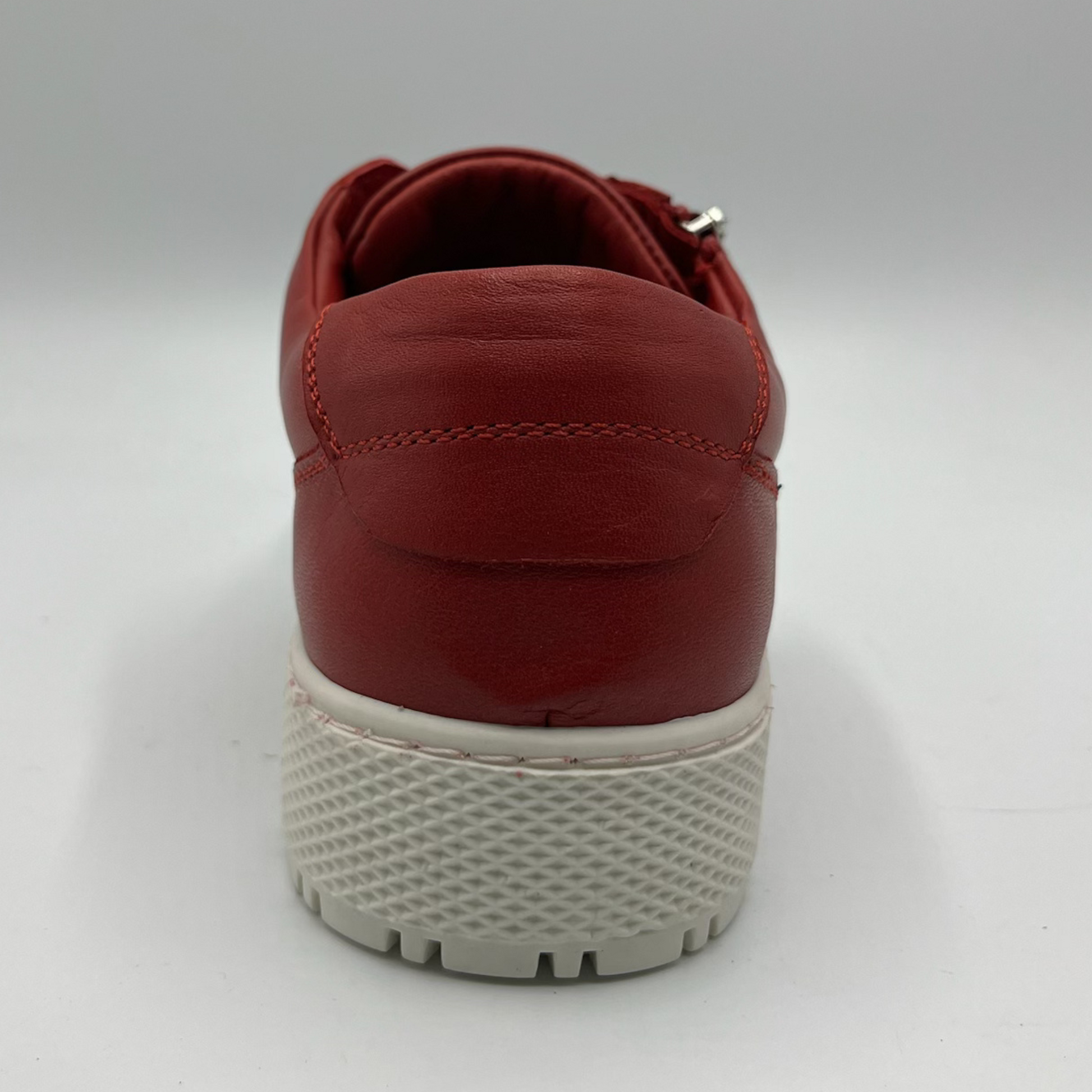 Back view of a red leather sneaker with a white rubber outsole