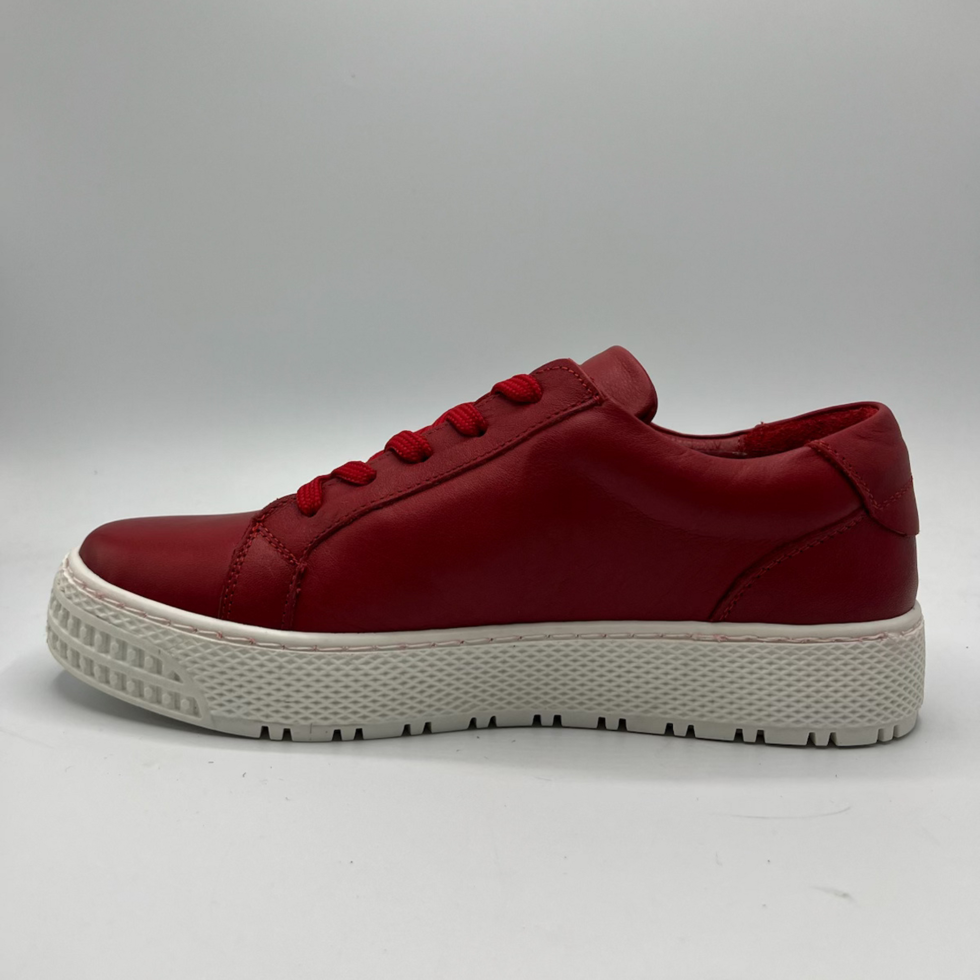Left facing view of a red leather sneaker with a white rubber outsole