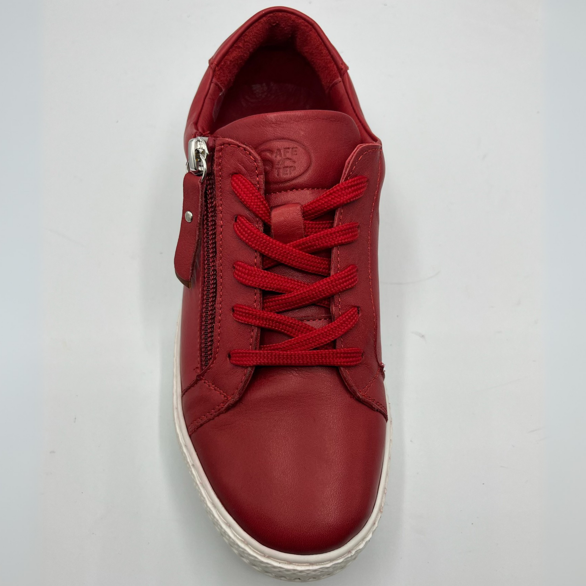 Top view of a red leather sneaker with a white rubber outsole