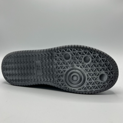 Close-up of a black sole with geometric pattern on a gray background