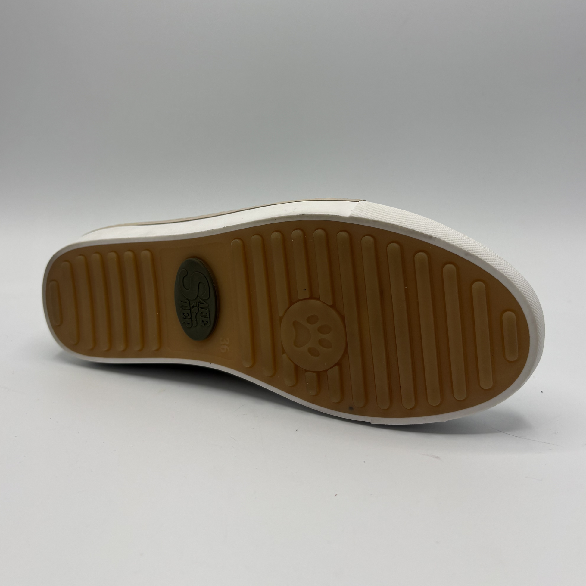 Bottom view of a beige perforated leather sneaker with a white rubber outsole