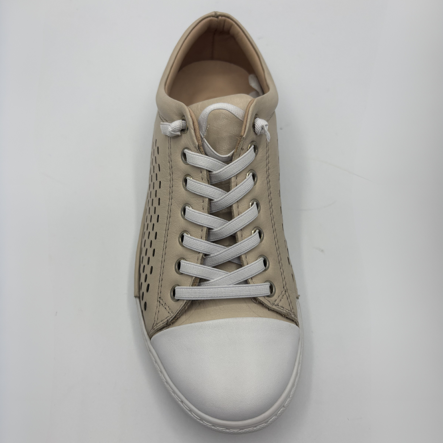 Top view of a beige perforated leather sneaker with a white rubber outsole