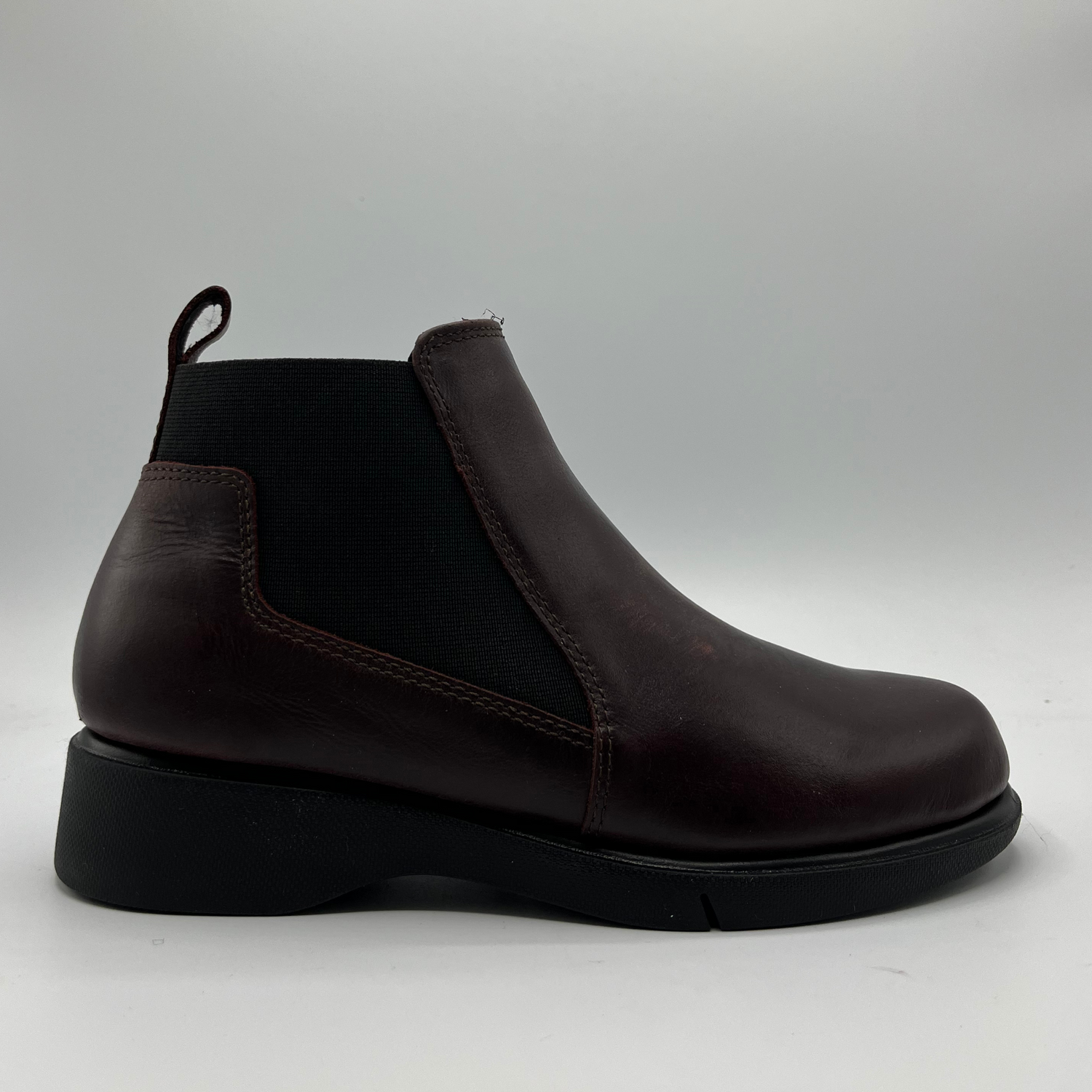 Brown leather Chelsea boot on a light gray background