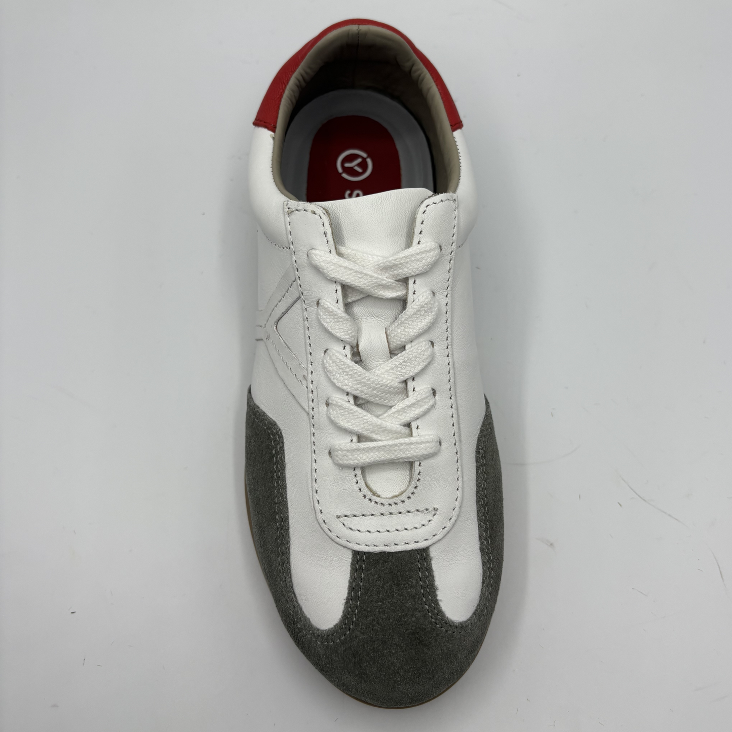 White and gray sneaker with red accents on a light gray background